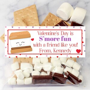 May include: A Valentine's Day gift bag with a red and white tag that says "Valentine's Day is S'more fun with a friend like you! From, Kennedy". The bag contains graham crackers, marshmallows, and chocolate squares.