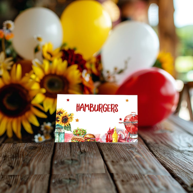 May include: White card with the text "HAMBURGERS" in red letters. The card has a watercolour illustration of a grill, hamburgers, hot dogs, and condiments on a red and white checked picnic blanket.