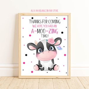 May include: A white sign with black polka dots and pink polka dots. The sign says "Thanks for coming. We hope you had an A-Moo-Zing time!" and features a cartoon black and white cow with a pink flower in its hair and a blue butterfly.