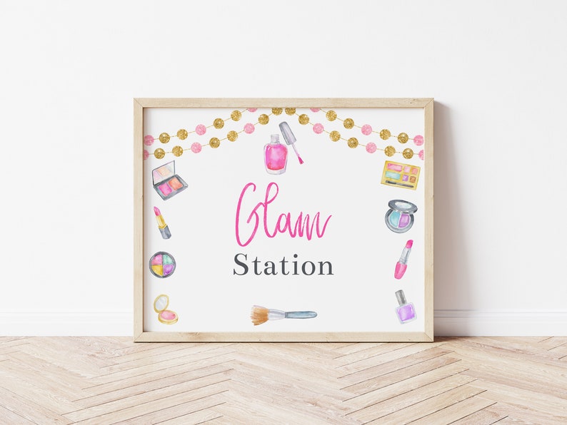 May include: A printable sign with the text "Glam Station" in pink lettering. The sign is decorated with watercolor illustrations of makeup products, including eyeshadow palettes, lipstick, nail polish, and brushes. A gold and pink garland is at the top of the sign.