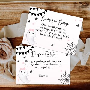 May include: Two baby shower cards with a Halloween theme. One card reads "Books for Baby" and the other reads "Diaper Raffle". Both cards feature a cute ghost illustration, black and pink accents, and text.