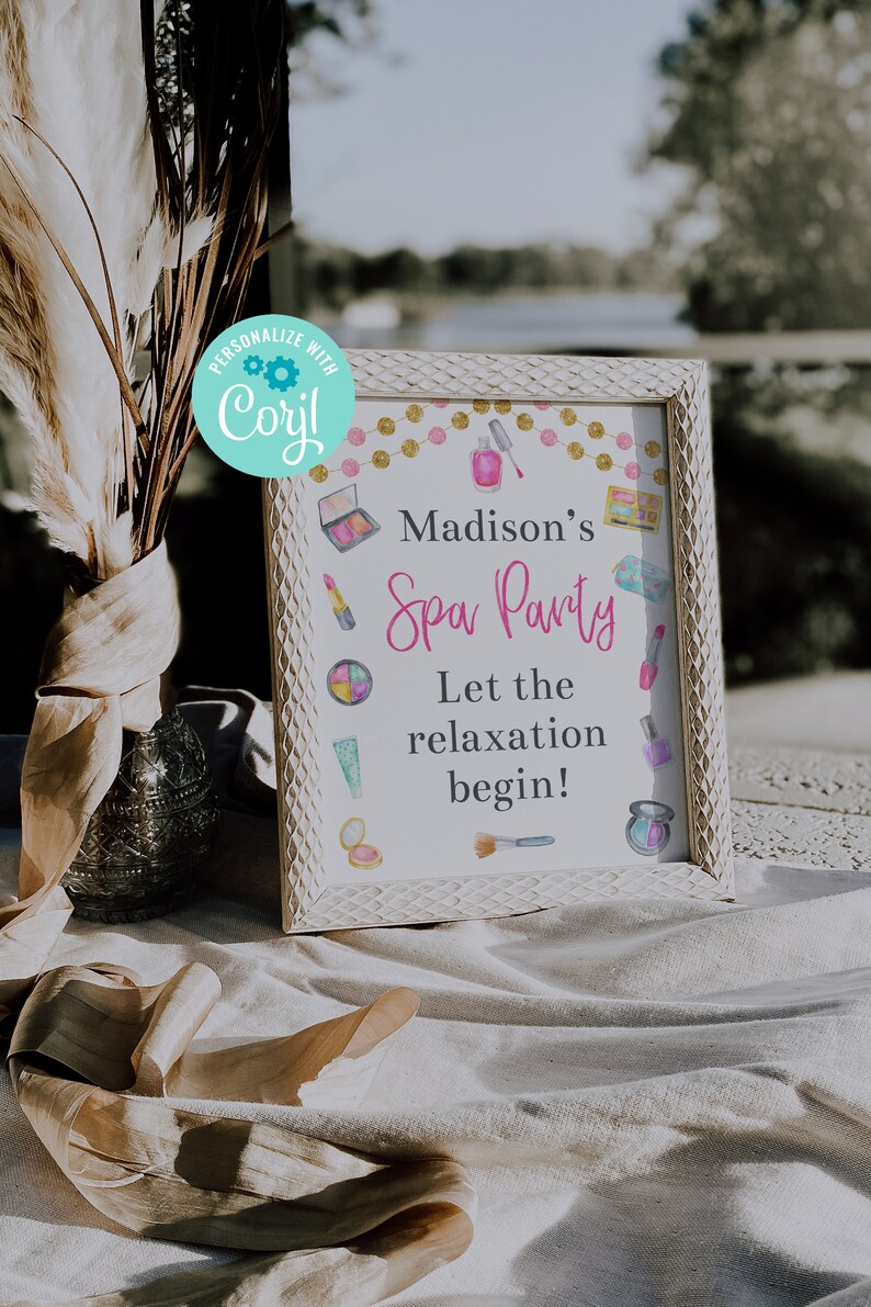 May include: A white framed sign with a pink and gold background. The sign says "Madison's Spa Party" and "Let the relaxation begin!" with images of makeup and spa items.