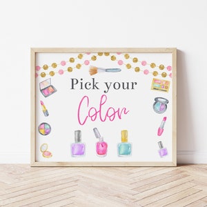 May include: A printable sign with the text "Pick your Color" in pink and black lettering. The sign is decorated with watercolor illustrations of makeup items, including nail polish, lipstick, eyeshadow, and a makeup brush. The sign is surrounded by a gold and pink garland.