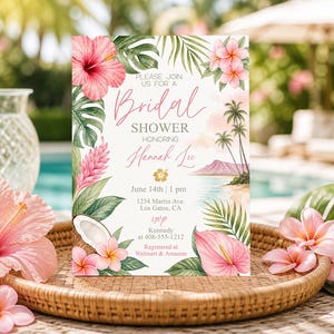 May include: Bridal shower invitation with tropical floral and beach theme. The invitation features pink hibiscus, plumeria, and palm leaves. Text reads "Bridal Shower Honoring Hannah Lee" with event details. The invitation is set on a woven tray with additional flowers.
