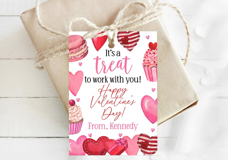 May include: A Valentine's Day gift tag with a pink and red watercolor design featuring cupcakes, hearts, and a macaron. The text reads "It's a treat to work with you! Happy Valentine's Day! From, Kennedy."
