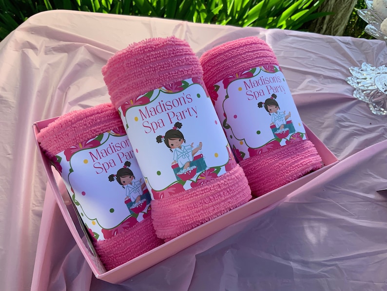 K&ouml;nnte beinhalten: Drei rosa Handt&uuml;cher in einer rosa Box mit einem Blumendesign und dem Text "Madison's Spa Party" auf jedem Handtuch.