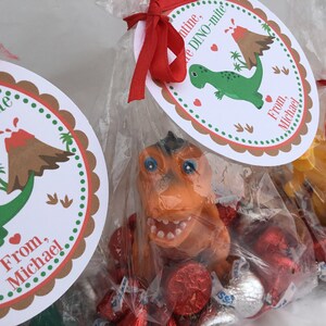 Puede incluir: Un conjunto de tres bolsas de golosinas para el D&iacute;a de San Valent&iacute;n con etiquetas de tem&aacute;tica de dinosaurios. Cada bolsa contiene caramelos de chocolate rojos y plateados y un peque&ntilde;o juguete de dinosaurio. Las etiquetas dicen "You are DINO-mite" y "From, Michael".
