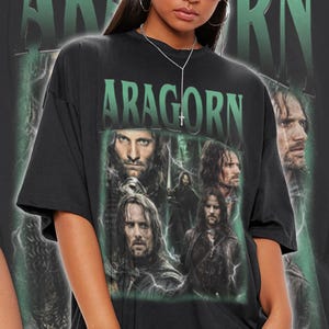 May include: Black t-shirt with a green graphic print of Aragorn from the Lord of the Rings. The graphic features multiple images of Aragorn in different poses.