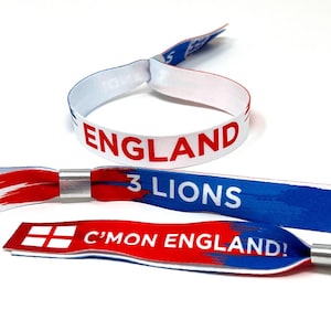 May include: Three fabric wristbands featuring red, white, and blue colors. One wristband is looped and displays the text ENGLAND. The other two are flat with metal closures, featuring the text 3 LIONS and C'MON ENGLAND! with a red cross icon.