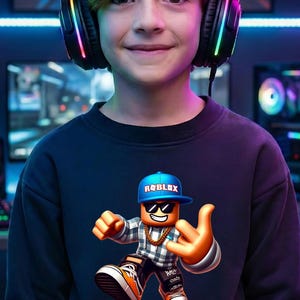 以下が含まれることがあります： サングラス、青いキャップ、金のチェーンを身に着けたRobloxのキャラクターが描かれたネイビーブルーのスウェットシャツ。キャラクターは手のジェスチャーをしています。画像内の人物は、カラフルなライト付きのヘッドフォンを着用しています。