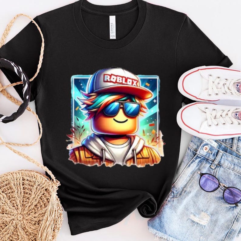 May include: A black t-shirt with a graphic of a Roblox avatar wearing a blue and red hat with the word 'ROBLOX' on it. The avatar has rainbow hair, sunglasses, and a yellow face. The avatar is wearing a brown jacket and is standing in front of a colorful background.