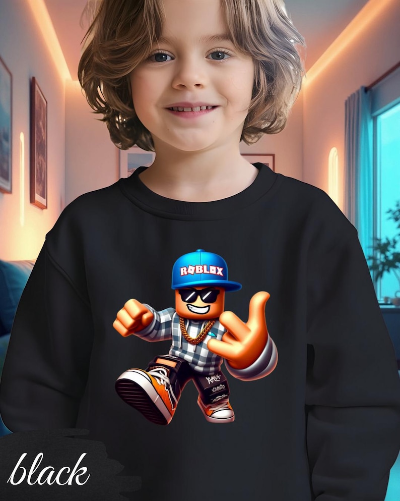 以下が含まれることがあります： 黒いスウェットシャツ。青い Roblox ロゴのキャップ、サングラス、金のチェーンを身に着けたカラフルな Roblox キャラクターが特徴です。キャラクターはハンドジェスチャーをしています。「black」の文字が下部に印刷されています。