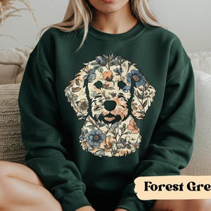 May include: Forest green sweatshirt featuring a floral dog design. The dog's silhouette is filled with a pattern of flowers in shades of blue, peach, and cream. The text "Forest Green" is displayed in a tan rectangle at the bottom.