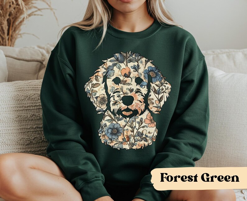 May include: Forest green sweatshirt featuring a floral dog design. The dog's silhouette is filled with a pattern of flowers in shades of blue, peach, and cream. The text "Forest Green" is displayed in a tan rectangle at the bottom.