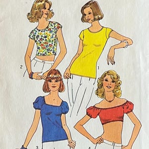 Könnte beinhalten: Simplicity-Schnittmusterumschlag für Tops mit einem Yard Stoff, Größe 14 & 16. Das Cover zeigt Illustrationen von vier verschiedenen Tops in verschiedenen Farben, darunter Gelb, Blau und Rot. Die Schnittmusternummer ist 6902.