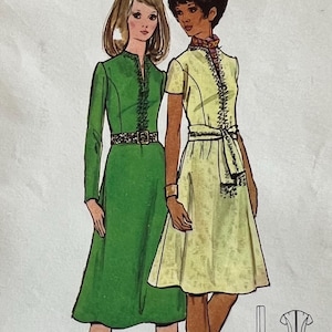 May include: Vintage Butterick sewing pattern 6020 featuring two women modeling dresses. The pattern includes a green long-sleeve dress and a yellow short-sleeve dress. The pattern size is 8, with a bust measurement of 31 1/2 inches.