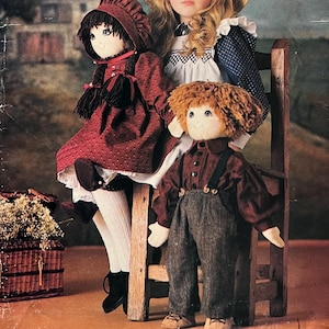 以下が含まれることがあります： ヴィンテージVogue Patterns 624 Craftのパターン封筒。3体の手作りの人形が写っています。人形はヴィンテージスタイルの服を着ています。封筒は青色で、Vogueのロゴと「PATTERN/PATRON 624 CRAFT」の文字が書かれています。