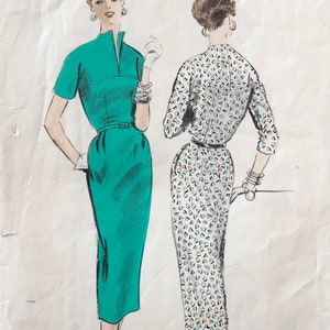 May include: A Vogue Pattern envelope 8233, size 16, featuring illustrations of a solid green dress and a patterned dress with a geometric print. The text includes 8233, 75c, in Canada 85c, size 16, 34 bust, 37 hip, Vogue Pattern, and copyright 1954.