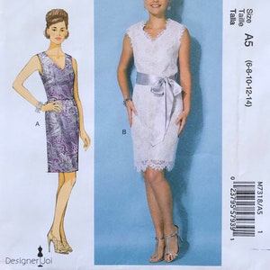 May include: A McCall's M7318 sewing pattern envelope featuring two dress variations. View A shows a purple paisley print sleeveless dress. View B shows a white lace sleeveless dress with a light gray satin sash. Includes size range A5 (6-8-10-12-14).