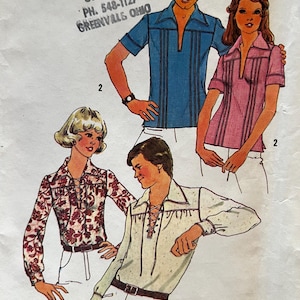 May include: Vintage sewing pattern with illustrations of four shirts. The shirts include a blue short-sleeve shirt, a pink short-sleeve shirt, a floral print shirt, and a white shirt with a lace-up front. The pattern is for a medium size, 38-40.