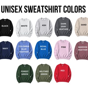 a collection of unisex sweatshirt colors, including black, white, ash, dark gray, heather, sand, navy, Colombia, royal blue, pink, maroon, forest green, military green, and red.