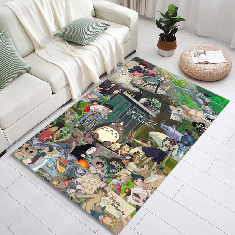 Pu&ograve; includere: Un tappeto colorato con personaggi di film dello Studio Ghibli, tra cui Totoro, Senza Faccia e Kiki Consegne a Domicilio. Il tappeto ha uno sfondo verde con una variet&agrave; di personaggi e scene dai film.