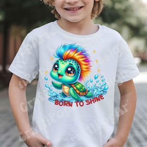 May include: White t-shirt featuring a cartoon turtle with a colorful mohawk and the text "BORN TO SHINE". The turtle is depicted in blue water with sparkling accents, creating a vibrant and playful design.