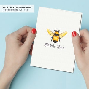 a person holding a card with a bee on it