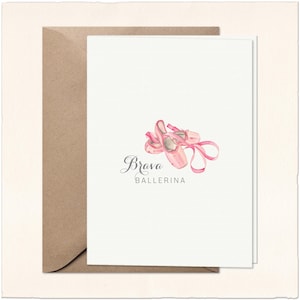 May include: A white card with a watercolor illustration of pink ballet shoes and the text "Brava Ballerina." The card is paired with a brown envelope, perfect for sending a special note.