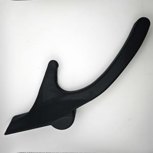 May include: A black plastic hook with a curved shape and a small round base. The hook is designed to hang items on a wall or other surface.