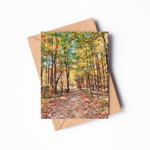 Puede incluir: Una pintura de acuarela de un camino a través de un bosque en otoño. Los árboles son una mezcla de hojas verdes y amarillas. El camino está bordeado de hojas caídas.
