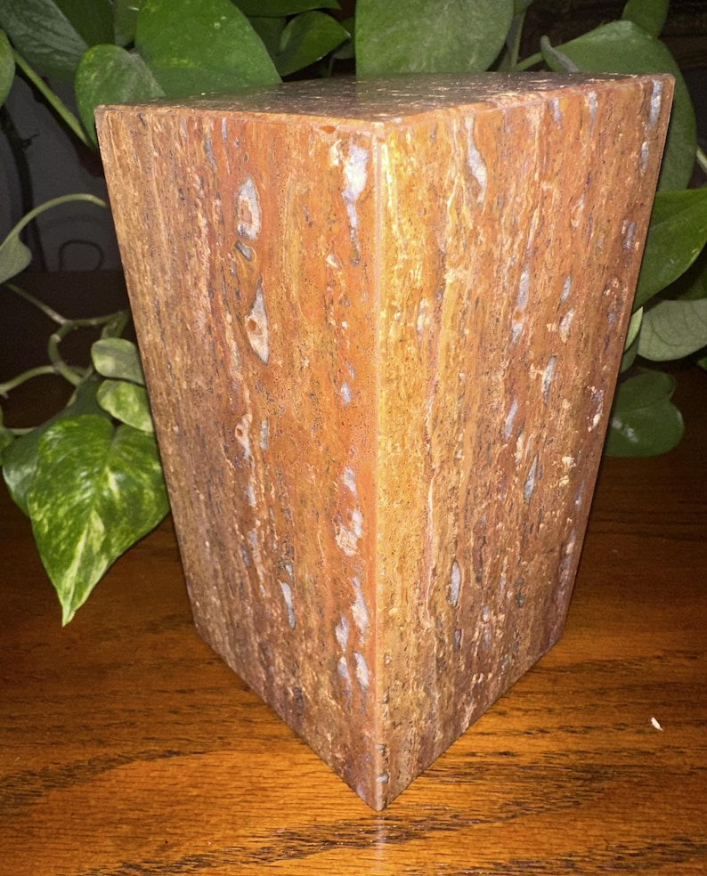 May include: A rectangular block of brown, orange, and white marble with a textured surface.