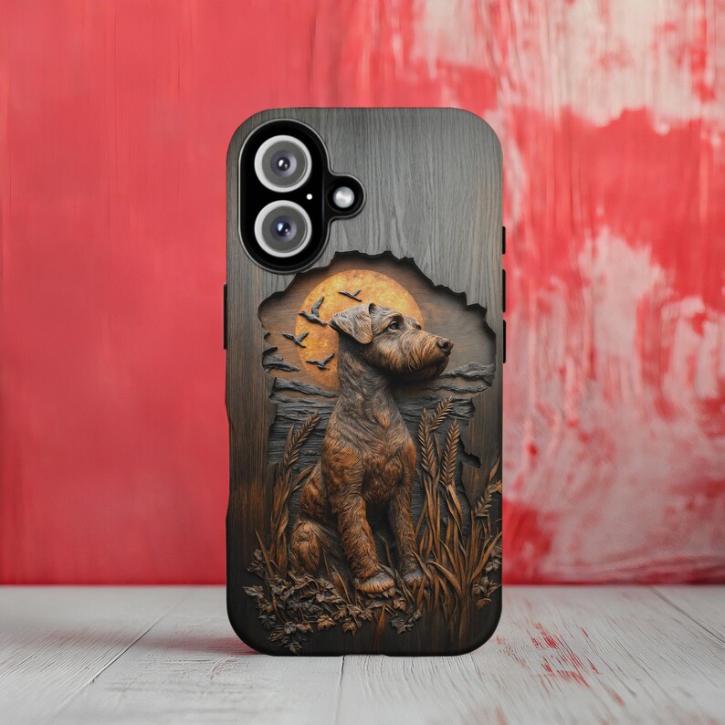 May include: A phone case with a detailed, carved design featuring a dog sitting in a field with a sunset backdrop. The case has a wood-grain texture and a dark brown and tan color scheme. The phone's camera lenses are visible at the top.