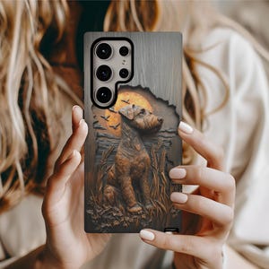 May include: A phone case with a detailed relief of a dog, wheat, and a sunset. The case has a wood-grain texture and a brown and orange color scheme. The dog is the central focus, with a sunset and birds in the background.