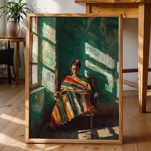 以下が含まれることがあります： 緑色の壁と窓から差し込む日光のある部屋に、カラフルなショールを着た人物が座っている様子を描いた額入りのアートワーク。 アートワークは木の床に立てかけられており、背景には他の木製家具や植物があります。
