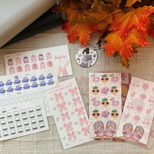 May include: A collection of stickers featuring perfume bottles, bows, laptops, phones, flamingos, pineapples, and sandals. The stickers are in various colors, including pink, blue, and white. The text "Perfumes" and "Bows & Bling, it's a Budget Thing" are visible.