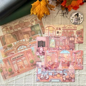 May include: A collection of illustrated cards featuring whimsical scenes of shops and buildings. The cards have a soft pink and beige color palette, with detailed drawings of animals and text such as "Harvest Home Pantry" and "Willow Wealth Bank."