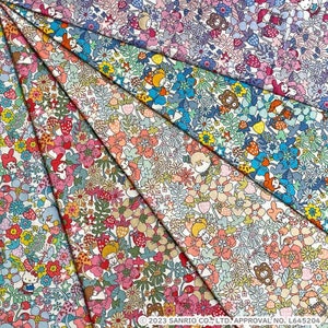 May include: A collection of six fabric panels featuring a whimsical floral pattern with strawberries, mushrooms, and small animal characters. The panels are arranged in a fan shape, with the colors gradually transitioning from light blue to pink.