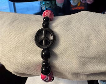 Uniek vervaardigde kralenarmband met vredesteken
