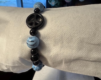 Uniek vervaardigde kralenarmband met vredesteken