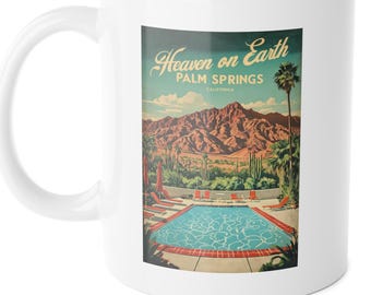 Op de afbeelding: Witte keramische mok met een retro-illustratie van een zwembad en palmbomen. De tekst "Heaven on Earth Palm Springs California" staat op de mok gedrukt.