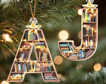 May include: Two wooden Christmas ornaments shaped like the letters "A" and "J", each filled with miniature books and fairy lights. The "A" ornament has the name "Amelia" and the "J" ornament has the name "Jessica" on them. Both ornaments are topped with a gold star.