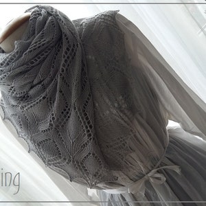 Könnte beinhalten: Ein graues Häkeltuch mit einem zarten Spitzenmuster. Das Tuch ist über eine weiße Kleiderpuppe gelegt. Der Text "Sterling" ist in der linken unteren Ecke des Bildes sichtbar. Der Text "a passion for lace..." ist in der rechten oberen Ecke des Bildes sichtbar.