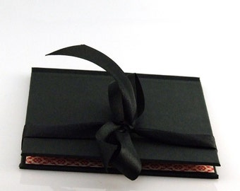 black DVD folio with elegant satin ribbon and red lining, CD packaging