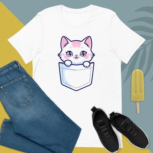 Gatito de Bolsillo – Camiseta de la Compañía Más Adorable. ¡Mantén la ternura cerca! Este gatito de bolsillo está listo para acompañarte con cada sonrisa. Camiseta unisex.