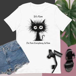 Unisex t-shirt   A funny fictional cartoon character to express feelings of stress and exhaustion in a fun way saying Its fine I am fine