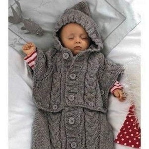 May include: A gray knitted baby sleeping bag with a hood. The sleeping bag has a cable knit pattern and buttons down the front.