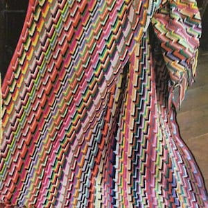 May include: A colourful crocheted blanket with a zig-zag pattern and fringe. The blanket is made with a variety of colours, including red, orange, yellow, green, blue, purple, and pink.