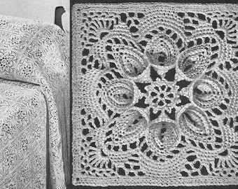 May include: A white crocheted blanket with a delicate floral pattern. The blanket is made up of repeating square motifs with a central star design.