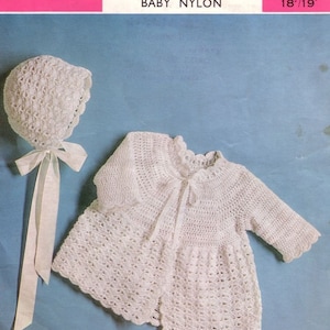 May include: A white crocheted baby bonnet and a white crocheted baby jacket with a white ribbon. The pattern is called "Cadette" and is made with 3 ply baby nylon.
